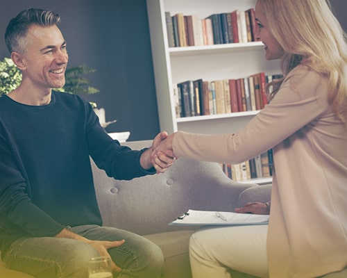 Мужчина пожимает руку женщине-психотерапевту